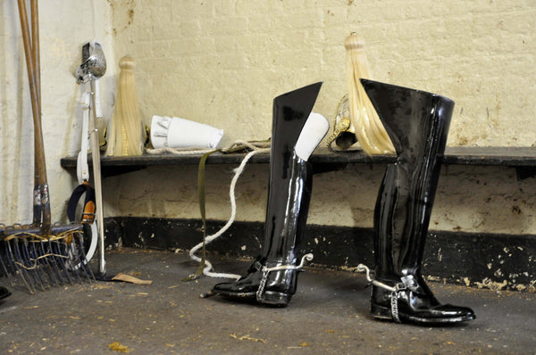 Ross Watson photograph of queens guard boots, helmut and sword discarded in stables