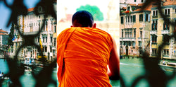 Ross Watson triptych photograph of orange robed monk with lattice obscured views of venice either side