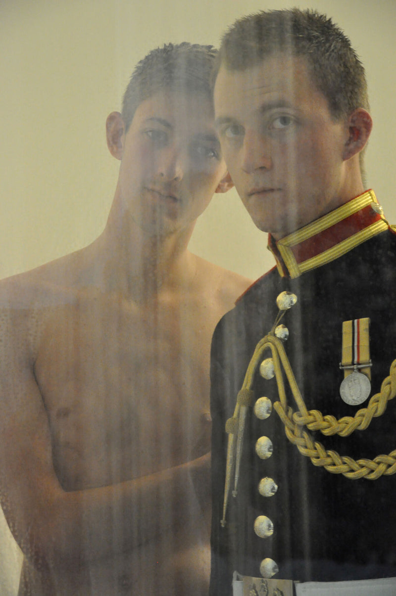Ross Watson photographic portrait of Lance Corporal James Wharton in formal uniform standing with undressed man in shower