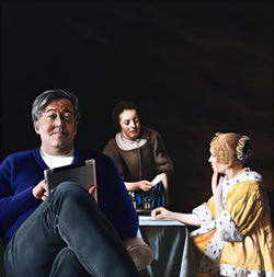 Painting of Stephen Fry sitting in blue sweater and jeans using an ipad with vermeer's painting of the maid receiving a letter in the background which features an aristocratic women in a yellow ermine robe seated at a table receiveing a letter from her maid dressed in a brown smock
